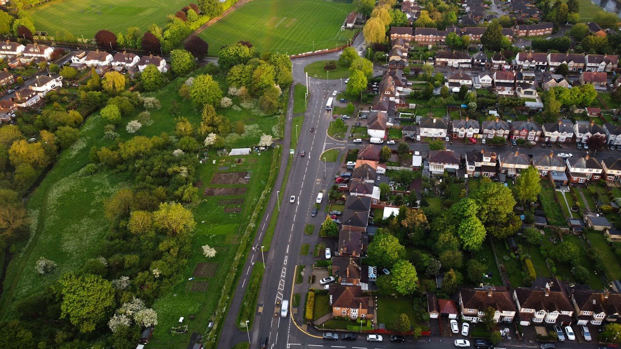 Stunning aerial view of Luton showcasing residential suburbs, roads, and lush green spaces.